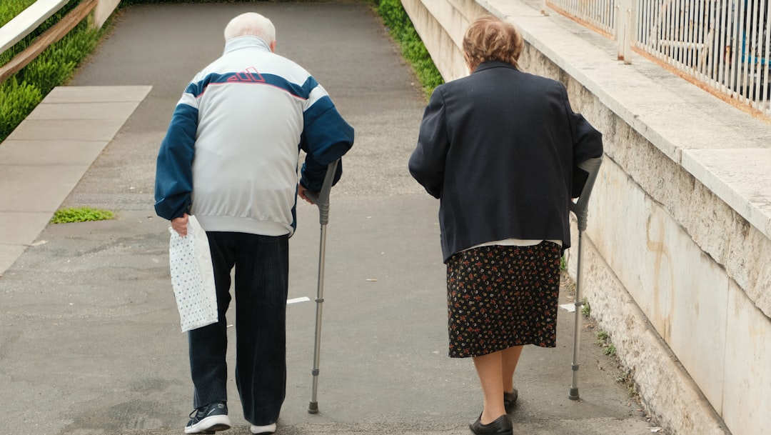 Two older women smiling and chatting over a cup of tea